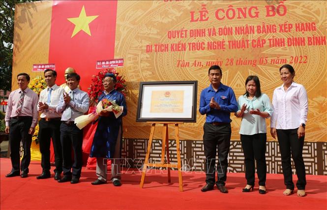 Ông Nguyễn Minh Hùng, Chủ tịch UBND thành phố Tân An chúc mừng Ban quản lý Di tích Đình Bình Lập- Ảnh: Thanh Bình-TTXVN