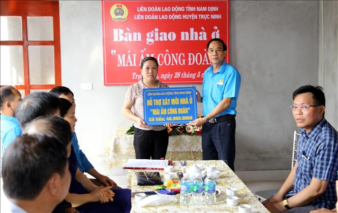 Trong ảnh: Lãnh đạo Liên đoàn Lao động tỉnh Nam Định trao biển tượng trưng số tiền đoàn viên Công đoàn tỉnh Nam Định hỗ trợ xây dựng “Mái ấm Công đoàn” cho gia đình chị Mai Thị Hiền, công nhân Công ty TNHH Shin Myung First Vina (huyện Trực Ninh). Ảnh: Văn Đạt - TTXVN