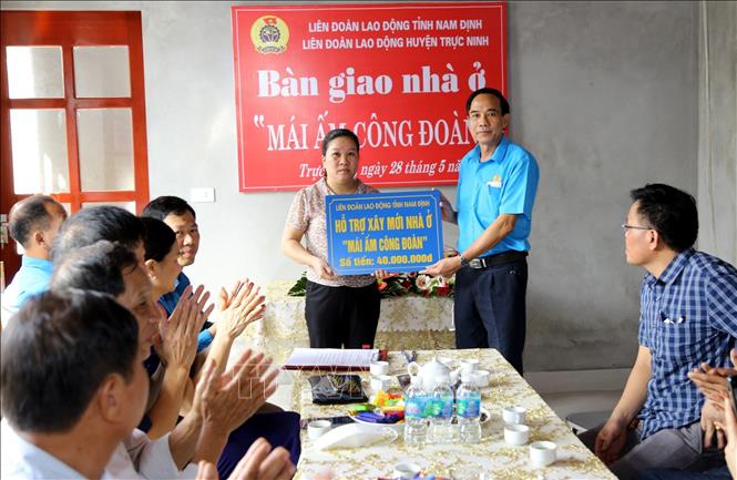 Trong ảnh: Lãnh đạo Liên đoàn Lao động tỉnh Nam Định trao biển tượng trưng số tiền đoàn viên Công đoàn tỉnh Nam Định hỗ trợ xây dựng “Mái ấm Công đoàn” cho gia đình chị Mai Thị Hiền, công nhân Công ty TNHH Shin Myung First Vina (huyện Trực Ninh). Ảnh: Văn Đạt - TTXVN