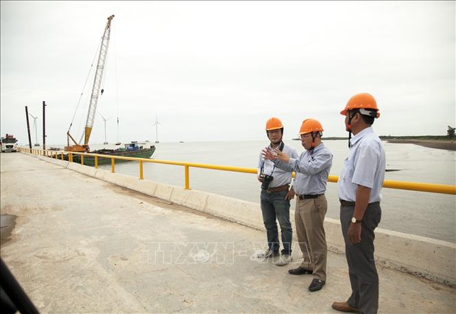 Trong ảnh: Tổng Giám đốc Công ty Cổ phần Tân Hoàn Cầu Mai Văn Long (giữa) giới thiệu về dự án điện gió của công ty tại tỉnh Bến Tre. Ảnh: Hồng Đạt - TTXVN

