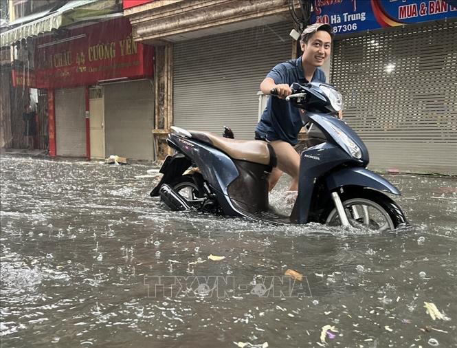 The water flooded vehicles on Ha Trung street. VNA Photo