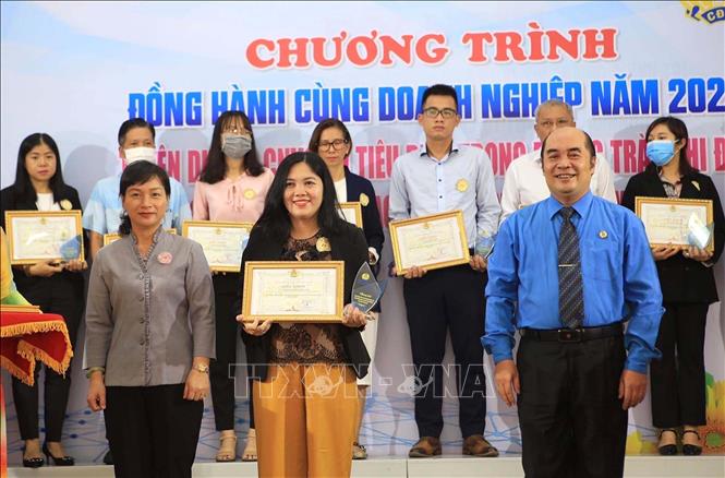 Trong ảnh: Ông Hồ Xuân Lâm, Phó Chủ tịch Liên đoàn Lao động Thành phố Hồ Chí Minh tặng biểu trưng, giấy khen chúc mừng các doanh nghiệp tiêu biểu đồng hành cùng người lao động năm 2022. Ảnh: Thanh Vũ - TTXVN
