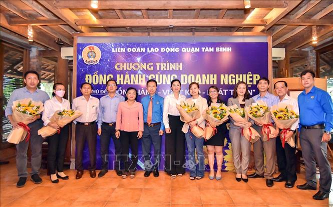 Trong ảnh: Đại diện Liên đoàn Lao động Thành phố Hồ Chí Minh tặng hoa chúc mừng các doanh nghiệp tiêu biểu đồng hành cùng người lao động năm 2022. Ảnh: Thanh Vũ - TTXVN