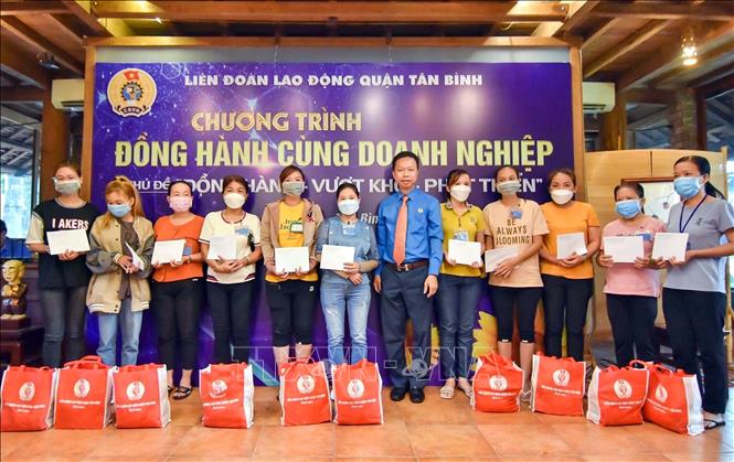 Trong ảnh: Đại diện Liên đoàn Lao động Thành phố Hồ Chí Minh cùng doanh nghiệp tặng quà cho công nhân lao động có hoàn cảnh khó khăn tại Lễ tuyên dương doanh nghiệp đồng hành cùng người lao động. Ảnh: Thanh Vũ - TTXVN