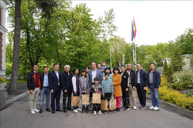 Vietnamese Ambassador to Russia Dang Minh Khoi pose for a group photo wit evacuees. VNA Photo: Duy Trinh