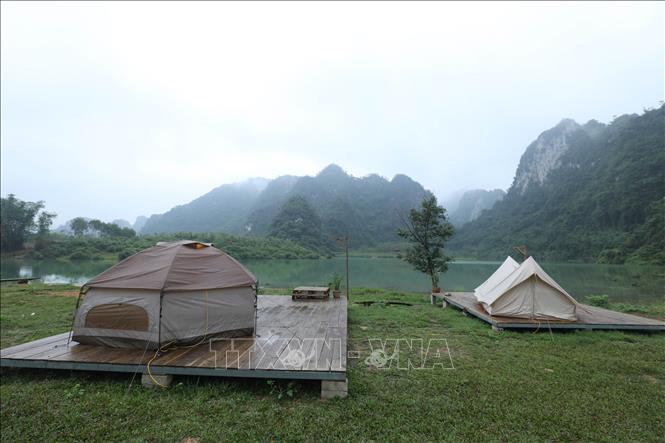 Trong ảnh: Du khách cắm trại nghỉ dưỡng quanh hồ Nong Dùng. Ảnh: Anh Tuấn – TTXVN
