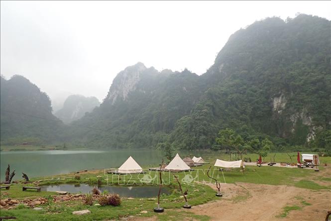 Trong ảnh: Du khách cắm trại nghỉ dưỡng quanh hồ Nong Dùng. Ảnh: Anh Tuấn – TTXVN