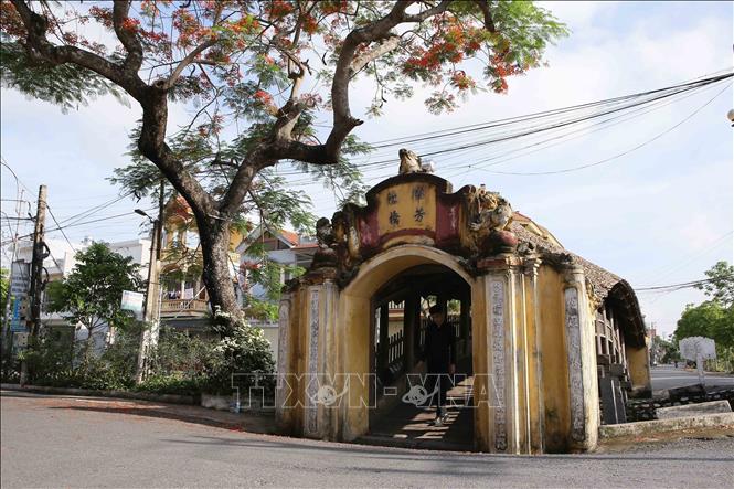 Trong ảnh: Cầu Ngói có kiến trúc cong như hình con rồng. Mùa hè, hoa phượng nở, đỏ thắm tô điểm thêm vẻ đẹp cây cầu. Ảnh: Công Luật - TTXVN

