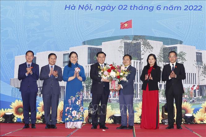 National Assembly Chairman Vuong Dinh Hue presents flowers to the group. VNA Photo: Doãn Tấn