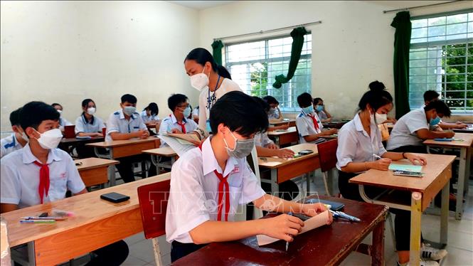 Trong ảnh: Giám thị phát giấy thi cho thí sinh trước môn thi Toán tại điểm thi Trường THPT Bùi Hữu Nghĩa. Ảnh: Thu Hiền - TTXVN