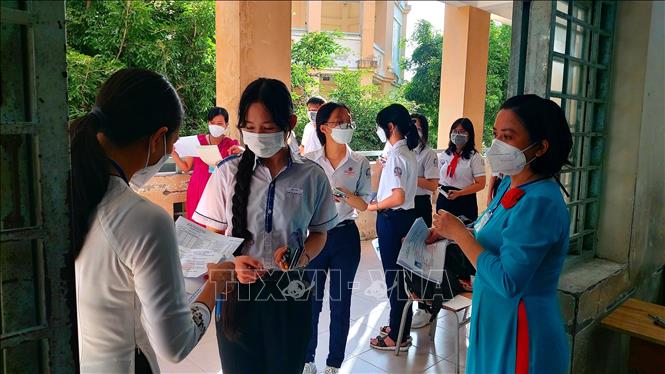 Trong ảnh: Giám thị kiểm tra thông tin thí sinh trước khi vào phòng thi tại điểm thi Trường THPT Bùi Hữu Nghĩa. Ảnh: Thu Hiền - TTXVN