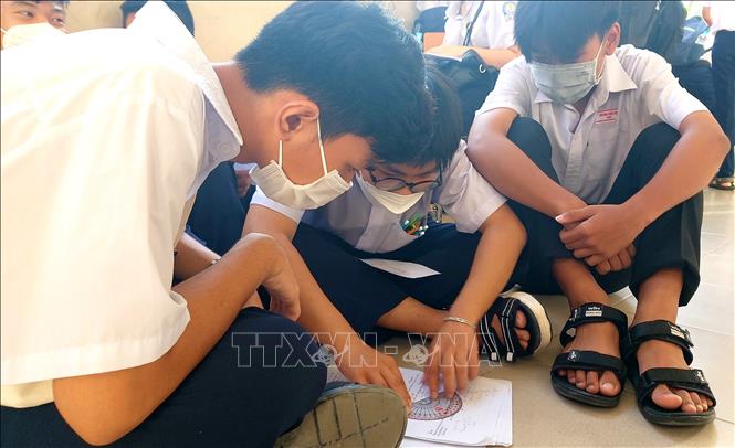 Trong ảnh: Các thí sinh tại điểm thi Trường THPT Bùi Hữu Nghĩa, quận Bình Thủy tranh thủ ôn bài trước giờ thi môn Toán. Ảnh: Thu Hiền - TTXVN