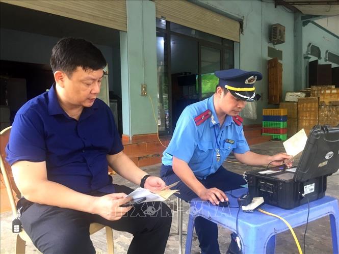 Trong ảnh: Lực lượng chức năng lập biên bản vi phạm đối với những xe vượt quá tải trọng. Ảnh: Tuấn Anh-TTXVN
