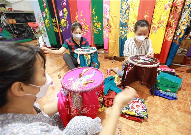 Làng nghề thêu Cổ Chất, xã Dũng Tiến, huyện Thường Tín hiện có khoảng 150 cơ sở và 200 hộ tham gia sản xuất các loại sản phẩm thêu trên áo dài, quần áo thời trang, trang phục biểu diễn... tạo việc làm thu nhập ổn định cho hàng nghìn lao động. Ảnh: Vũ Sinh - TTXVN