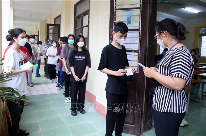 Giám thị gọi thí sinh vào phòng thi trong buổi thi môn Ngữ văn. Ảnh: Trung Kiên - TTXVN