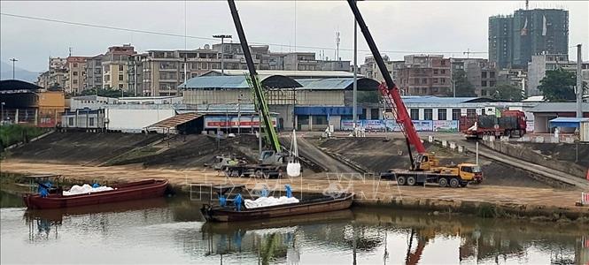 Trong ảnh: Đò chở bột sắn đầu tiên xuất khẩu sang Trung Quốc qua cửa khẩu Ka Long ngày thông quan trở lại. Ảnh: Bùi Đức Hiếu-TTXVN