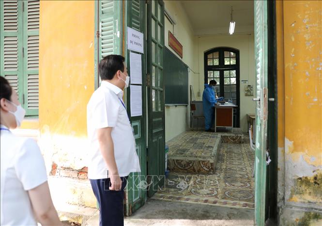 Phó Chủ tịch UBND TP Hà Nội Chử Xuân Dũng động viên thí sinh, giám thị phòng thi dự phòng tại điểm thi Trường THPT Chu Văn An, quận Tây Hồ. Ảnh: Thanh Tùng - TTXVN 