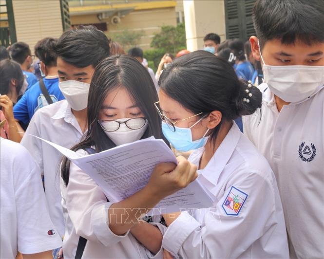 Thí sinh trao đổi bài làm môn Ngoại ngữ tại điểm thi Trường THPT Kim Liên, quận Đống Đa. Ảnh: Tuấn Đức - TTXVN
