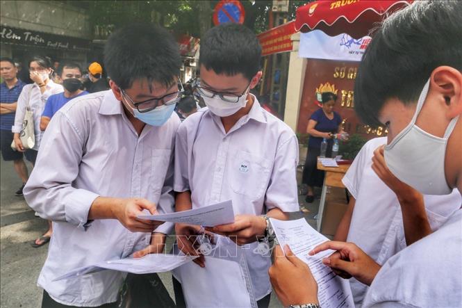Thí sinh trao đổi bài làm môn Ngoại ngữ tại điểm thi Trường THPT Kim Liên, quận Đống Đa. Ảnh: Tuấn Đức - TTXVN