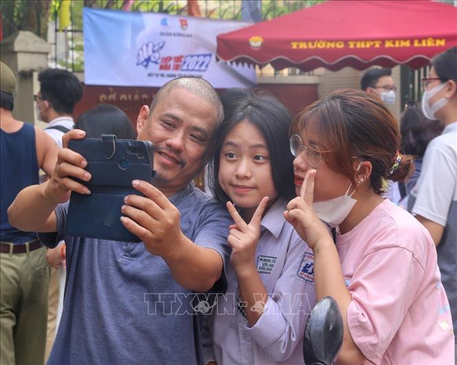 Thí sinh chụp ảnh lưu niệm cùng phụ huynh sau khi hoàn thành môn Ngoại ngữ tại điểm thi Trường THPT Kim Liên, quận Đống Đa. Ảnh: Tuấn Đức - TTXVN