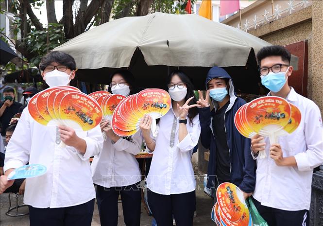 Các tình nguyện viên tại điểm thi điểm thi Trường THCS Ngô Quyền, quận Hai Bà Trưng, chiều 18/6. Ảnh: Hoàng Hiếu - TTXVN 