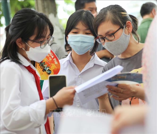 Thí sinh trao đổi sau khi hoàn thành bài thi Ngoại ngữ tại điểm thi Trường THPT Trần Nhân Tông, quận Hai Bà Trưng. Ảnh: Thanh Tùng - TTXVN 