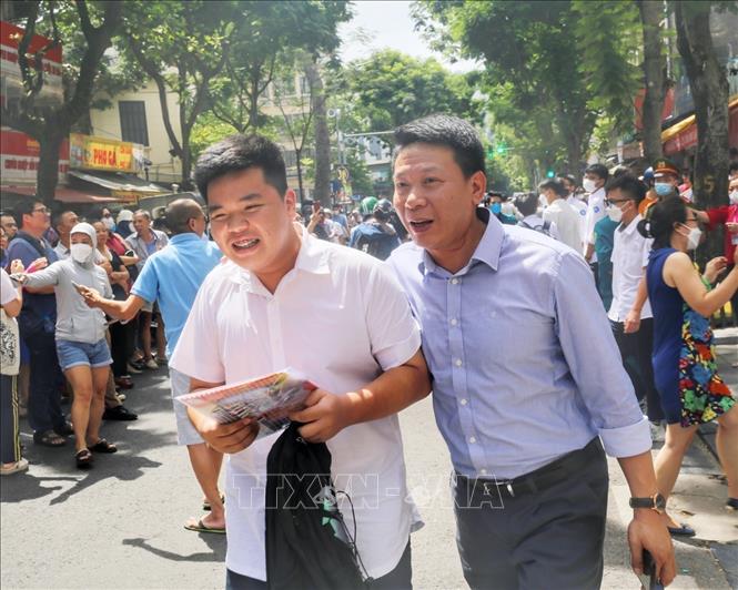 The joy of a student and his father after finishing the first subject - literature. VNA Photo: Tuấn Đức