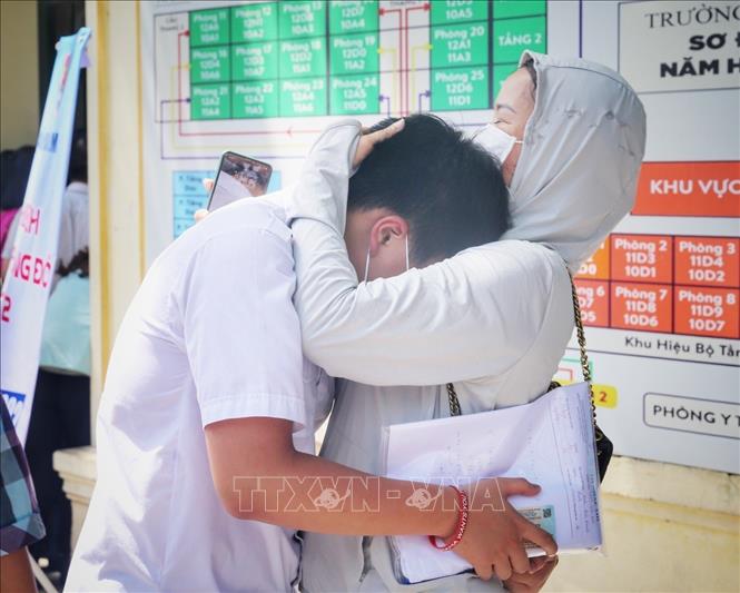Phụ huynh an ủi con vì làm bài không được như mong đợi. Ảnh: Tuấn Đức - TTXVN