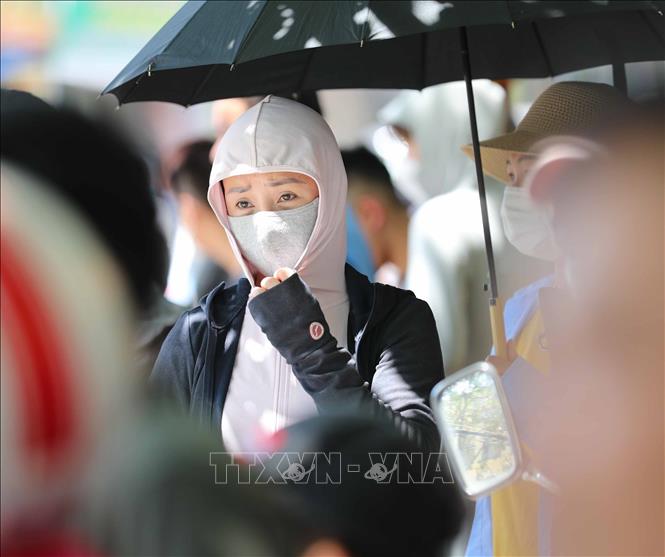 Phụ huynh đội nắng đón thí sinh thi môn cuối cùng tại điểm thi trường THCS thị trấn Trâu Quỳ, huyện Gia Lâm. Ảnh: Thanh Tùng - TTXVN 