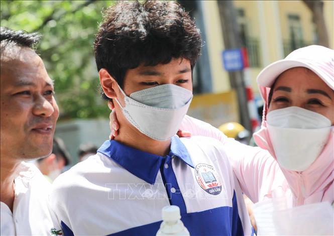 Phụ huynh đội nắng đón thí sinh thi môn cuối cùng tại điểm thi trường THCS thị trấn Trâu Quỳ, huyện Gia Lâm. Ảnh: Thanh Tùng - TTXVN 
