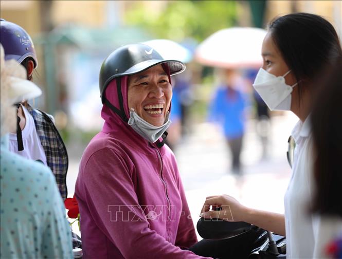 Phụ huynh rạng rỡ khi biết con làm được bài. Ảnh: Thanh Tùng - TTXVN 