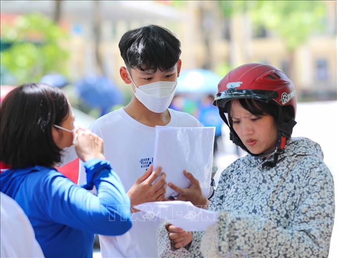 Học sinh trao đổi cùng phụ huynh sau khi hoàn thành môn thi Toán, môn thi cuối cùng tại điểm thi trường THCS thị trấn Trâu Quỳ, huyện Gia Lâm. Ảnh: Thanh Tùng - TTXVN