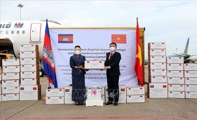 Bà Youk Sambath, Quốc vụ khanh Bộ Y tế Campuchia (trái), trao tượng trưng số hàng của Campuchia hỗ trợ công tác phòng, chống dịch COVID-19 của Thành phố Hồ Chí Minh, sáng 19/7/2021, tại sân bay Tân Sơn Nhất. Ảnh: Xuân Khu-TTXVN