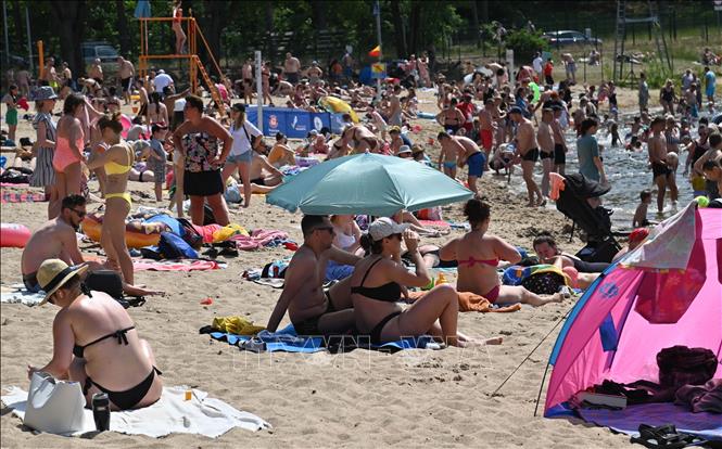 Nhiều nước châu Âu phải đối mặt với đợt nắng nóng nghiêm trọng trong 2 ngày cuối tuần qua khi nhiệt độ tại Biarritz (Pháp) lên tới gần 43 độ C, trong khi cháy rừng hoành hành tại Tây Ban Nha và tình trạng khô hạn, thiếu nước ở Italy đang khiến mùa màng thất bát. Trong ảnh: Người dân tránh nóng trên bãi biển tại Szczecin, Ba Lan, ngày 19/6/2022. Ảnh: PAP/TTXVN