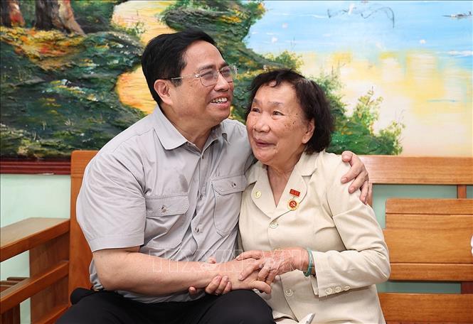 Thủ tướng Phạm Minh Chính thăm thương binh hạng ¼ Trần Thị Kim Cúc ở phường Thanh Long, quận Hải Châu. Ảnh: Dương Giang-TTXVN