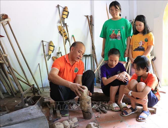 Trong ảnh: Nghệ nhân Nguyễn Thành Lai, trưởng phường rối nước Luy Lâu giới thiệu con rối đến với các em học sinh. Ảnh: Thanh Thương - TTXVN