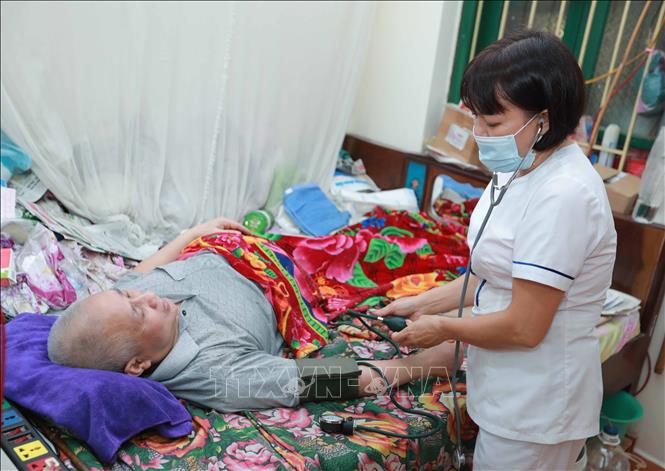 Y, bác sĩ trung tâm luôn quan tâm, kiểm tra sức khỏe, kịp thời đề ra phác đồ điều trị, đảm bảo sức khỏe cho các thương bệnh binh. Ảnh: Hoàng Hiếu - TTXVN