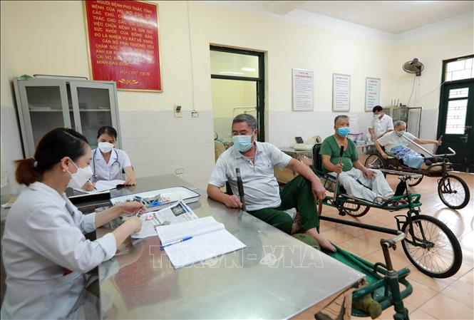 Các y, bác sĩ trung tâm luôn quan tâm, kiểm tra sức khỏe, cấp phát thuốc đúng phác đồ điều trị giúp các thương bệnh binh ổn định sức khỏe, tránh tái phát các vết thương. Ảnh: Hoàng Hiếu - TTXVN