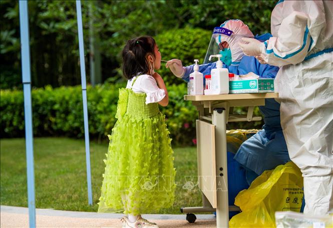 Trong ảnh: Nhân viên y tế lấy mẫu xét nghiệm COVID-19 cho người dân tại Thượng Hải, Trung Quốc. Ảnh: AFP/TTXVN