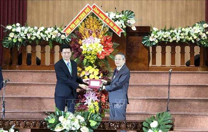 Nguyen Tien Trong, Vice Chairman of the Government Committee for Religious Affairs, presents flowers to representative of General Confederation of the Evangelical Church of Vietnam (South). VNA Photo: Xuân Khu