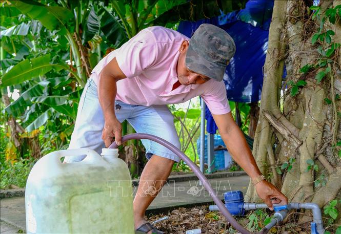 Trong ảnh: Người dân khu tái định cư và nhà ở công nhân Khu công nghiệp Hưng Phú 1 dùng can nhựa đi xin nước sạch ở Khu dân cư Tân Phú gần đó để đem về sử dụng. Ảnh: Thanh Liêm - TTXVN