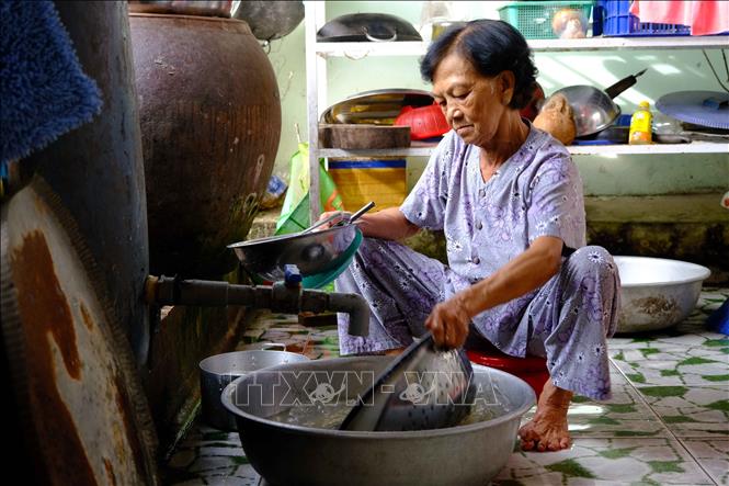 Trong ảnh: Gia đình bà Dương Thị Huệ (72 tuổi) bơm nước sông lên chứa trong thùng phuy để sử dụng vì không có nước sạch. Ảnh: Thanh Liêm - TTXVN