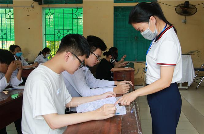 Trong ảnh: Cán bộ làm công tác thi hướng dẫn thí sinh tại điểm thi Trường THPT Trần Hưng Đạo, thành phố Nam Định, tỉnh Nam Định kiểm tra lại thông tin cá nhân và phổ biến quy chế thi. Ảnh: Nguyễn Lành - TTXVN