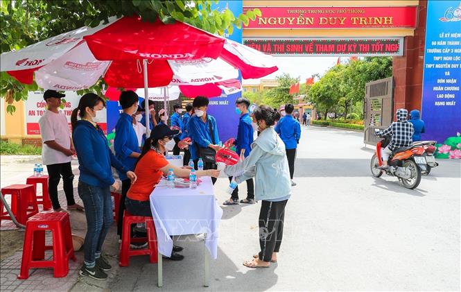 Trong ảnh: Thanh niên tình nguyện trường THPT Nguyễn Duy Trinh, huyện Nghi Lộc hỗ trợ thí sinh đến làm thủ tục dự thi. Ảnh: Bích Huệ - TTXVN