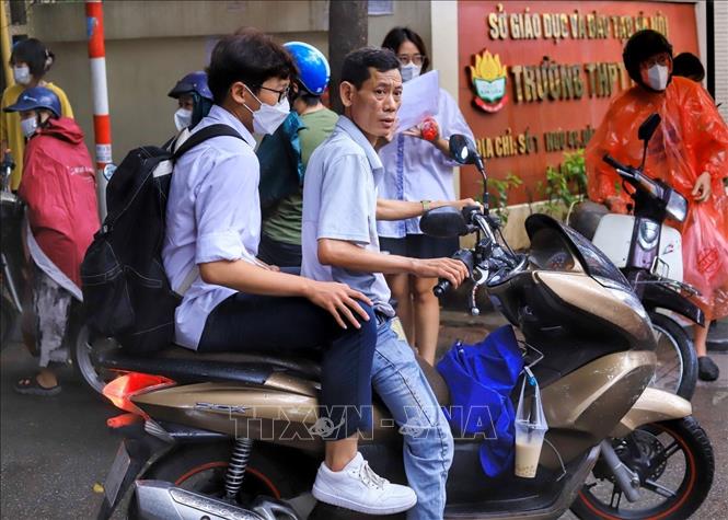 Phụ huynh đón thí sinh tại điểm thi Trường THPT Kim Liên, quận Đống Đa. Ảnh: Hoàng Nguyên - TTXVN phát