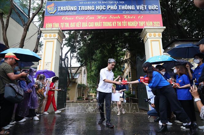 Các thí sinh rời khỏi điểm thi Trường THPT Việt Đức chiều 7/7 khi trời đang mưa. Ảnh: Hoàng Hiếu - TTXVN 