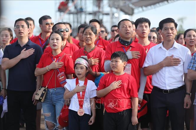 Người dân chào cờ tại sự kiện. Ảnh: Minh Quyết - TTXVN