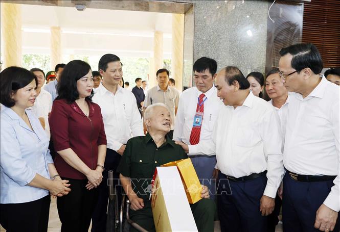 President Nguyen Xuan Phuc talks with sick soldiers at a nursing centre in Thuan Thanh district. VNA Photo: Thống Nhất