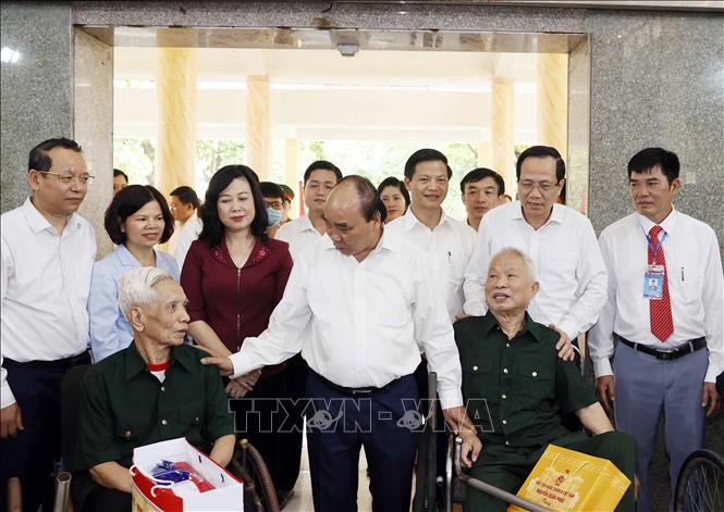 President Nguyen Xuan Phuc talks with sick soldiers at a nursing centre in Thuan Thanh district. VNA Photo: Thống Nhất