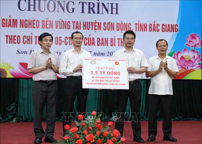 Trong ảnh: Trao biển tượng trưng hỗ trợ kinh phí xây dựng 50 căn nhà cho hộ nghèo. Ảnh: Danh Lam -TTXVN